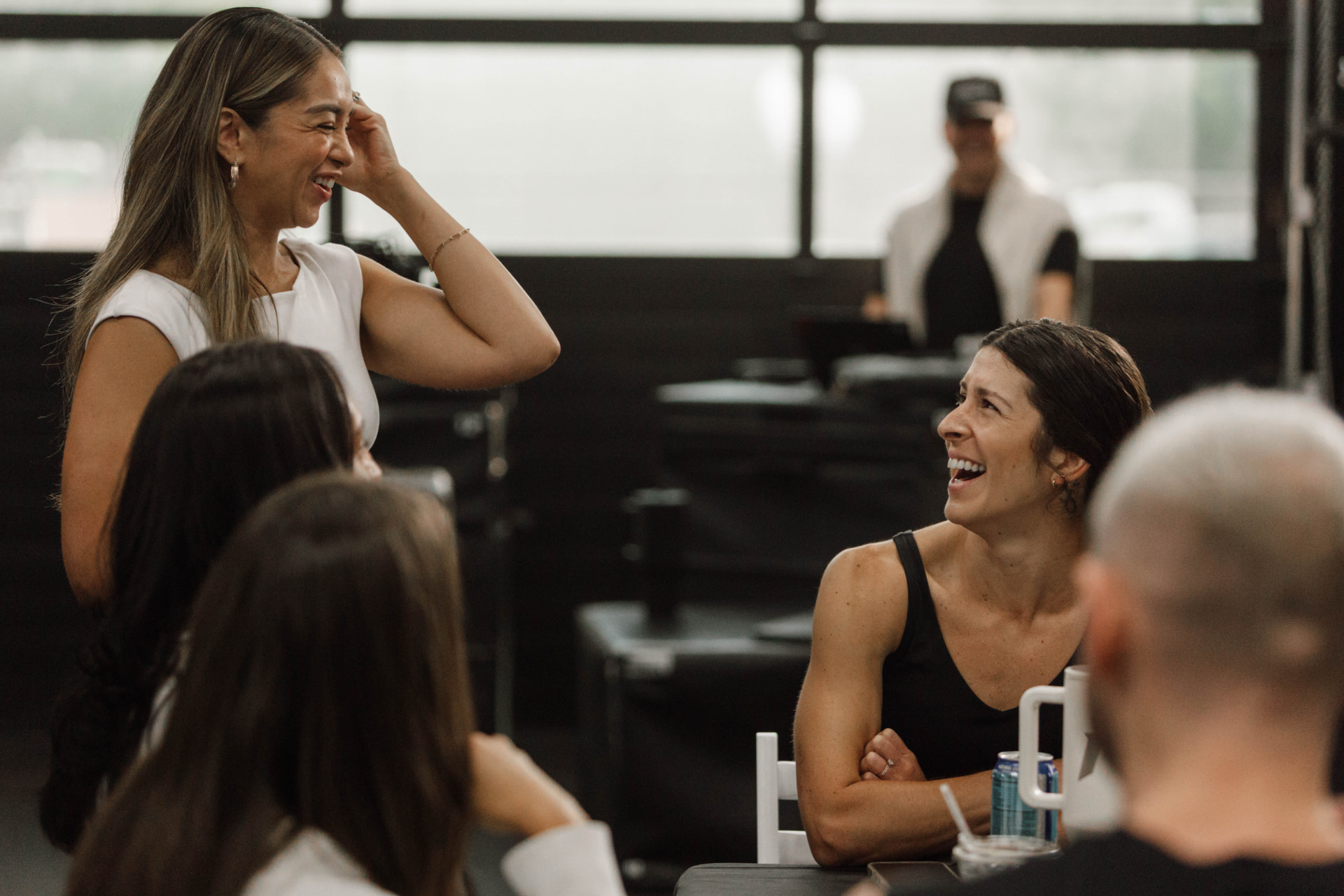 Women laughing together after a group training session in a studio